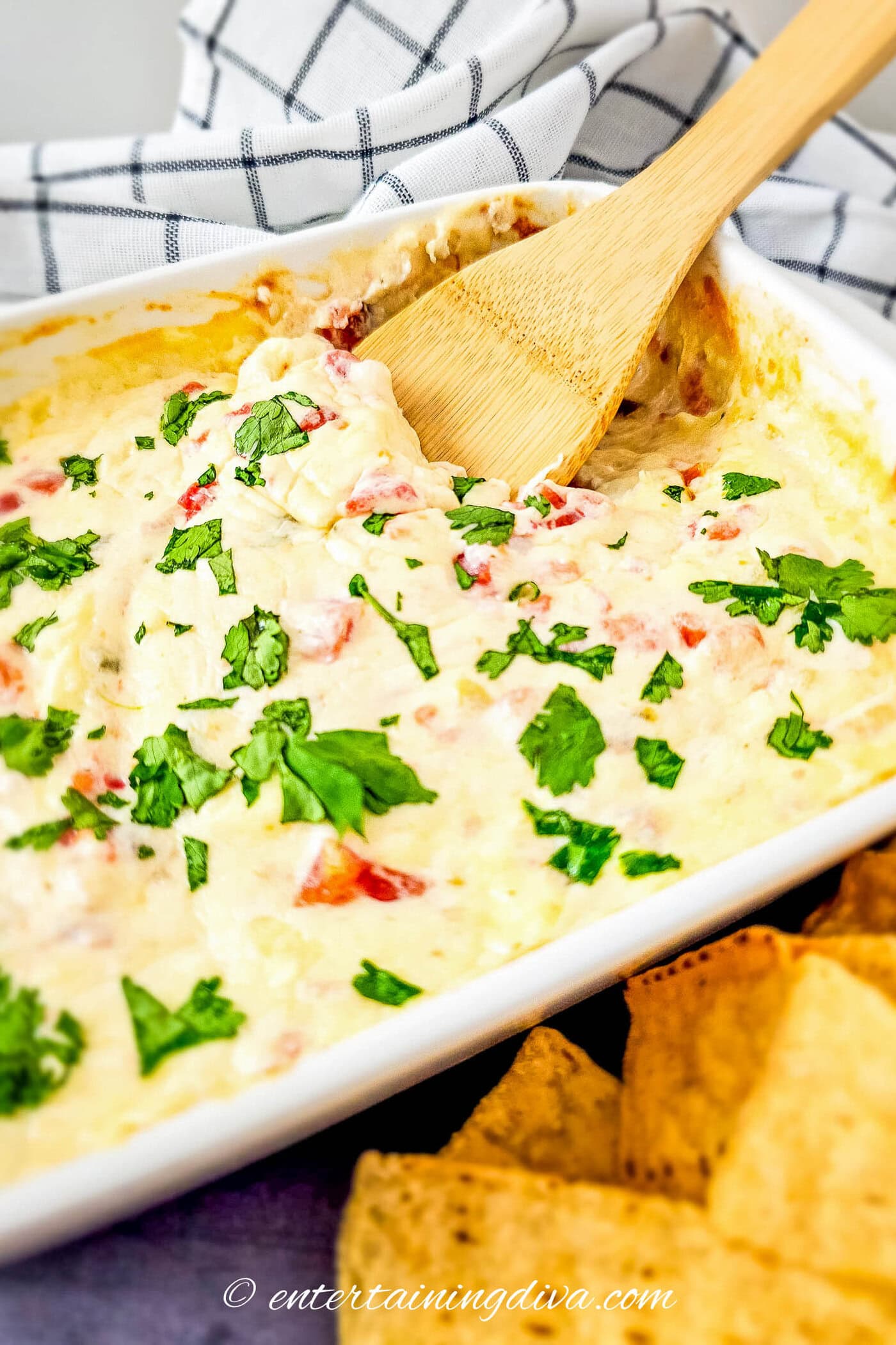 Queso blanco in a baking dish beside a pile of tortilla chips