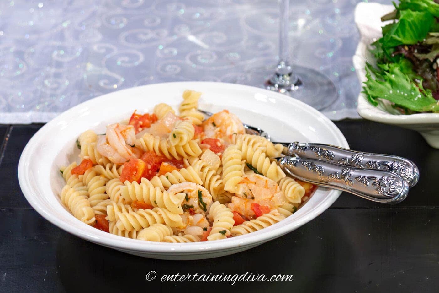 white Wine Lemon Herb Shrimp Rotini in a bowl with salad in the background