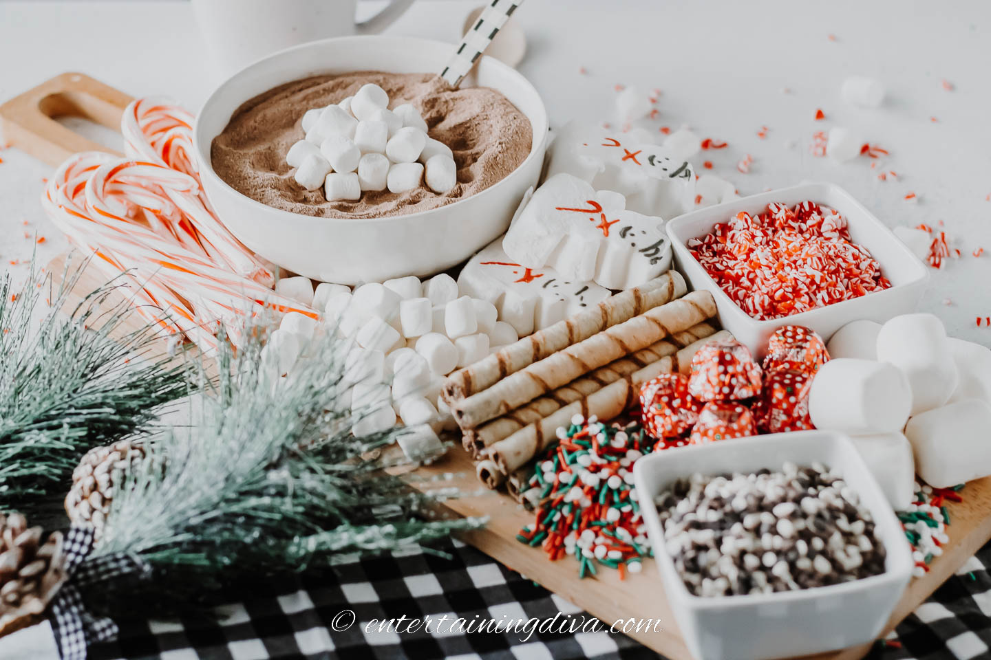 hot chocolate board with candy canes, mini marshmallows, sprinkles, and chocolate chips