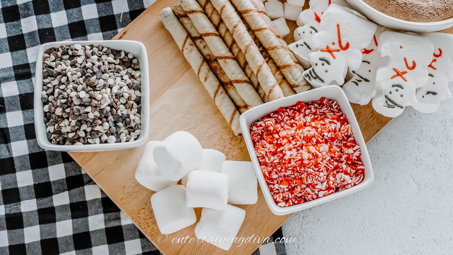 hot chocolate board with snowman peeps, wafer cookies, crushed candy canes, chocolate chips and marshmallows