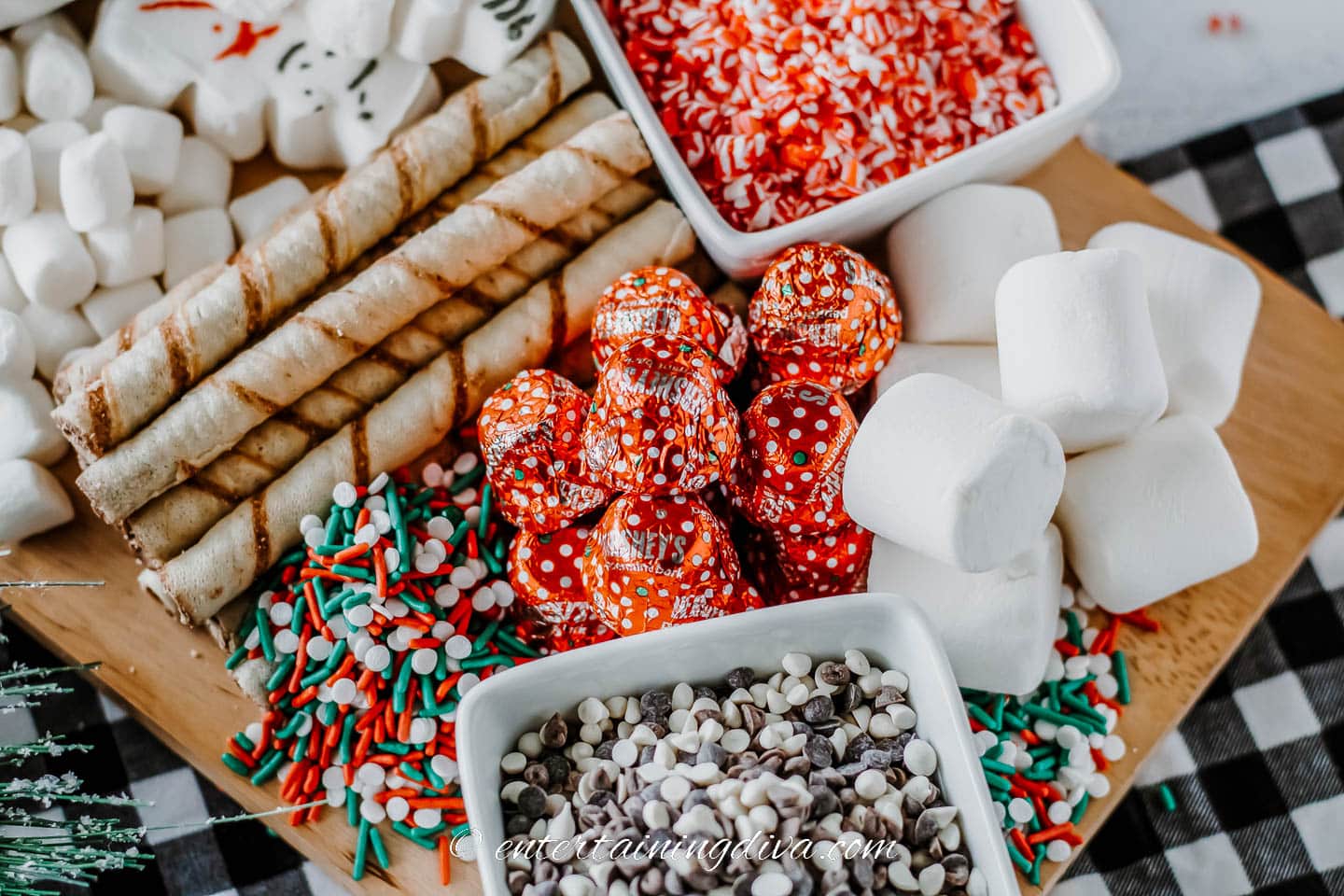 Close up of a hot chocolate charcuterie board with marshmallows, wafer cookies, sprinkles and mini chocolate chips