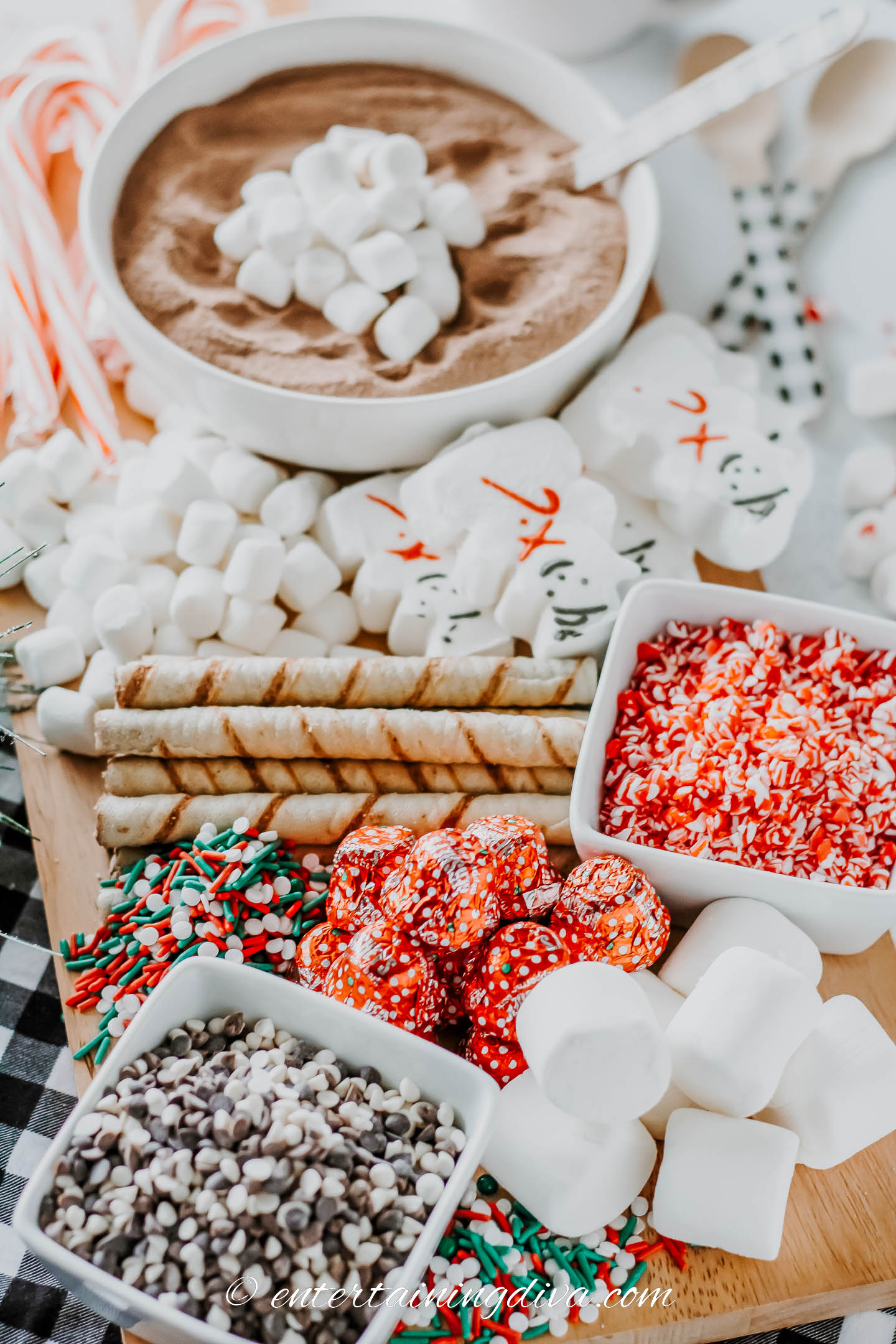 hot chocolate charcuterie board with hot cocoa mix, marshmallows, candy canes, sprinkles, wafer cookies and chocolate hcips