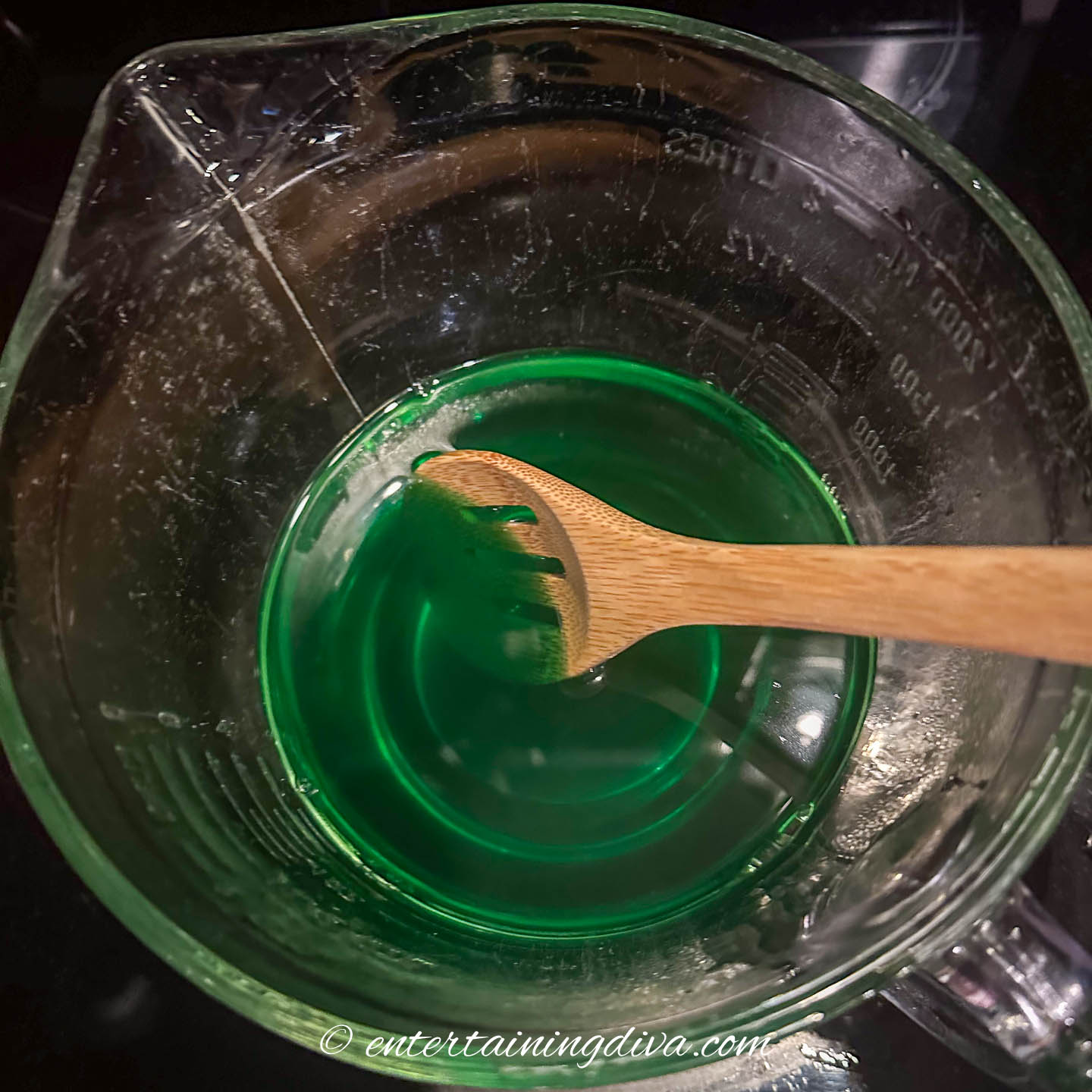 green jello being mixed in a clear bowl
