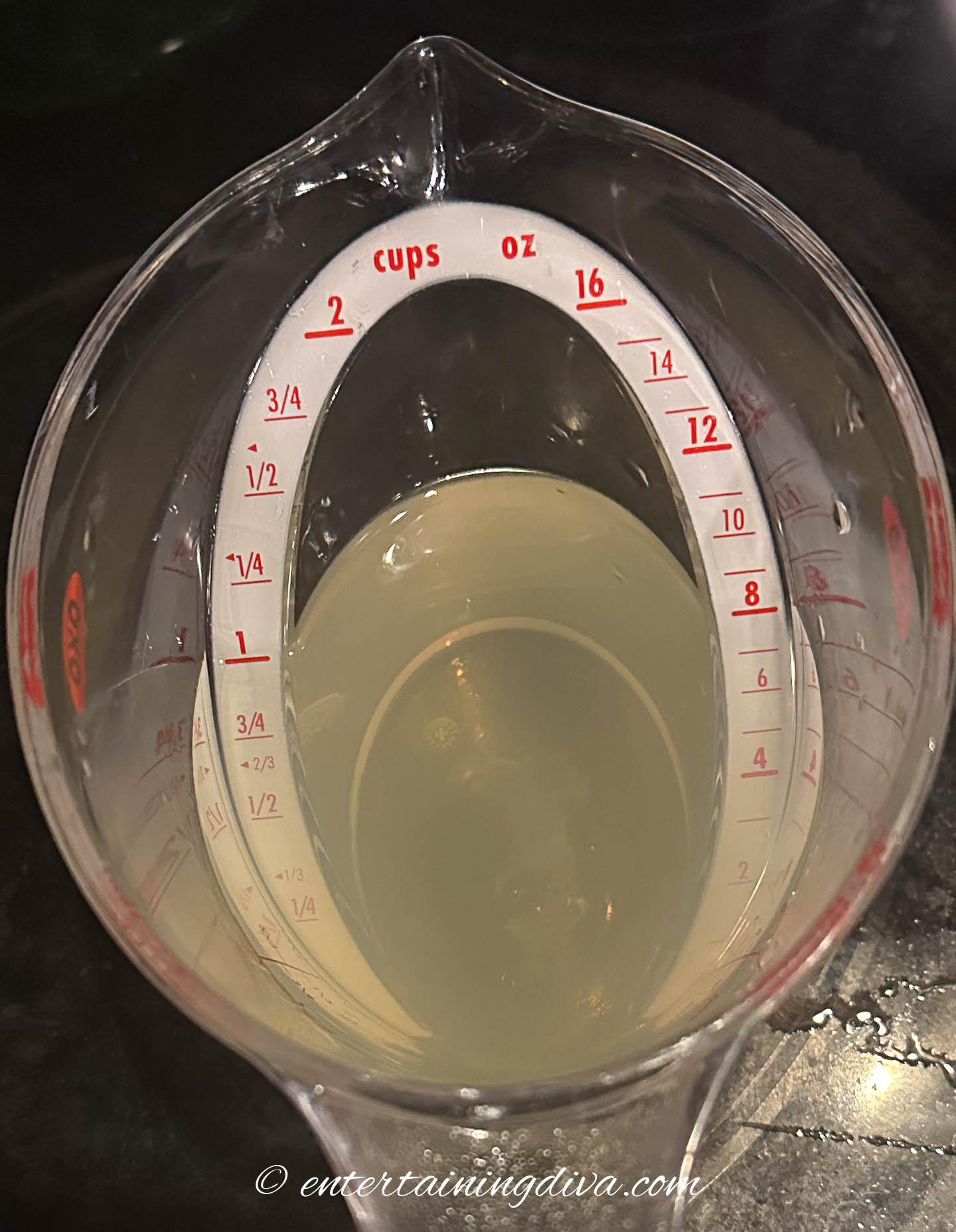 Tequila and margarita mix in a measuring cup