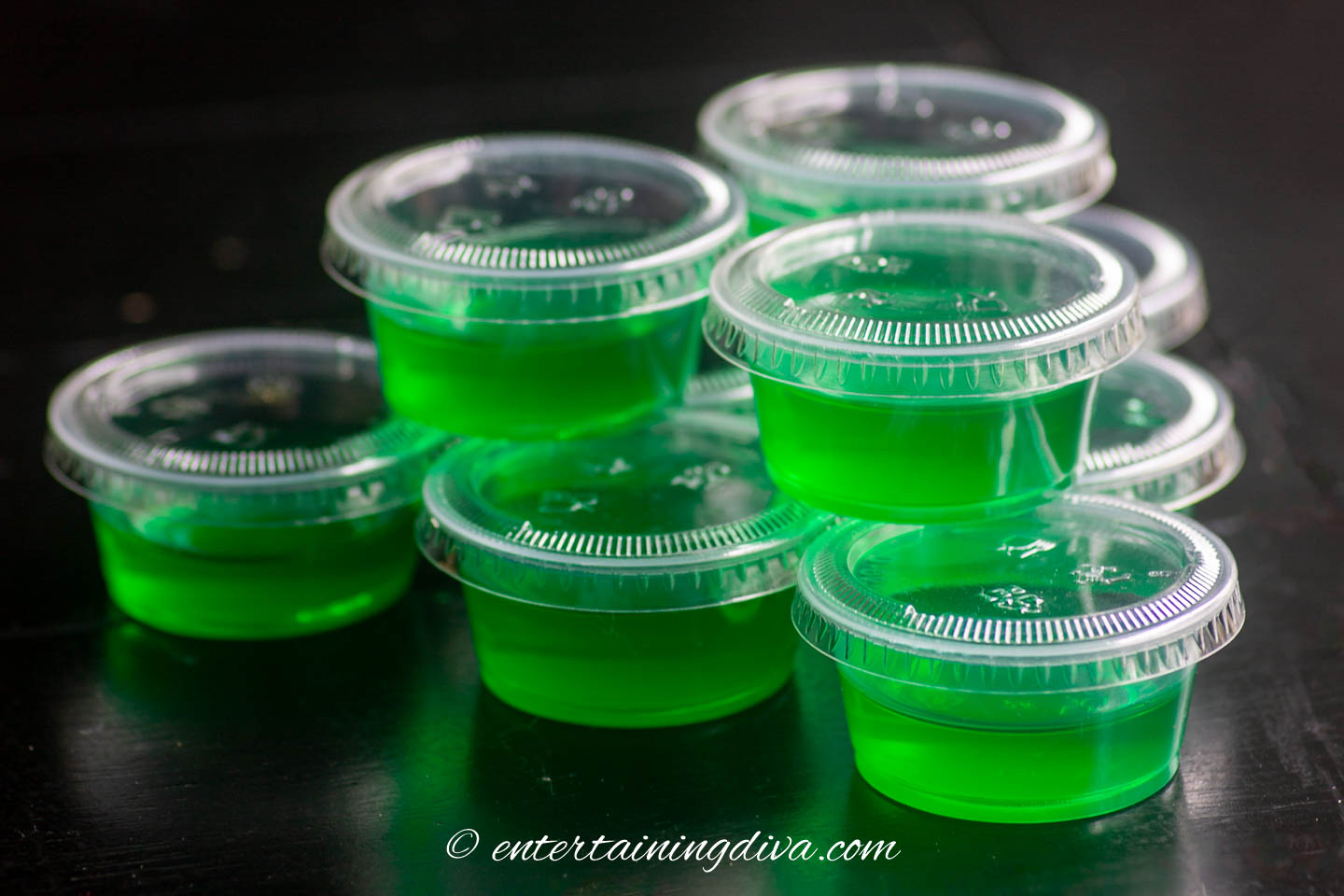 A stack of Margarita Jello shots in shot cups with lids
