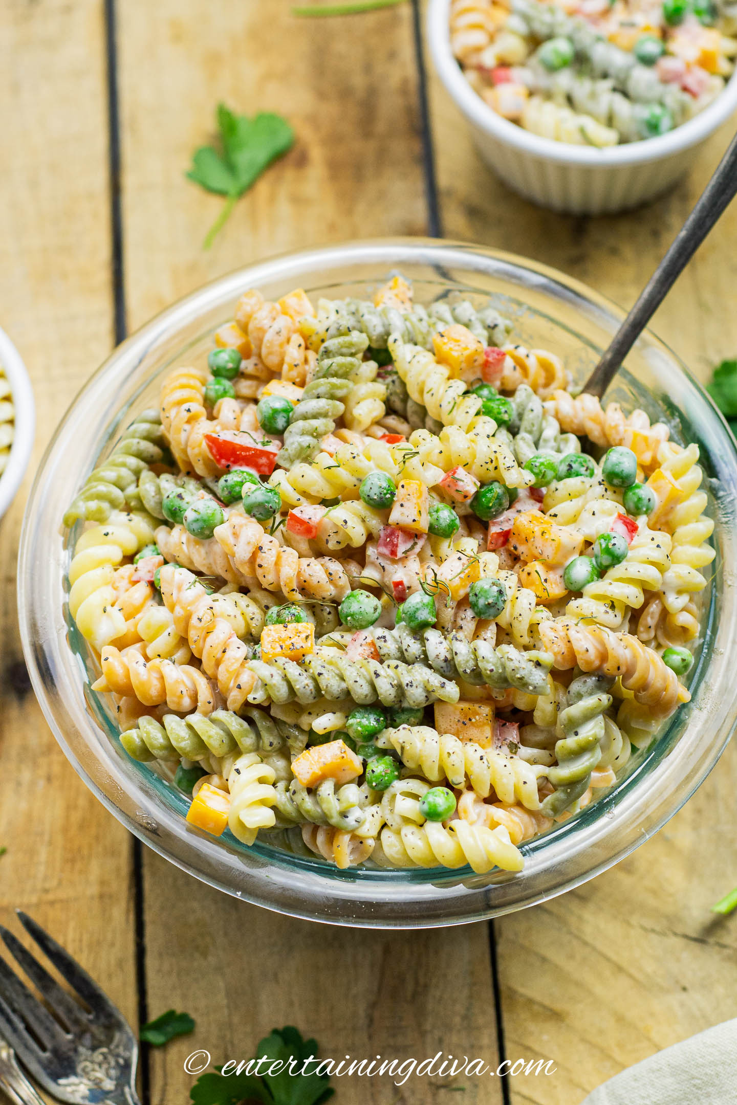 close up of creamy pasta salad with peas and bell peppers