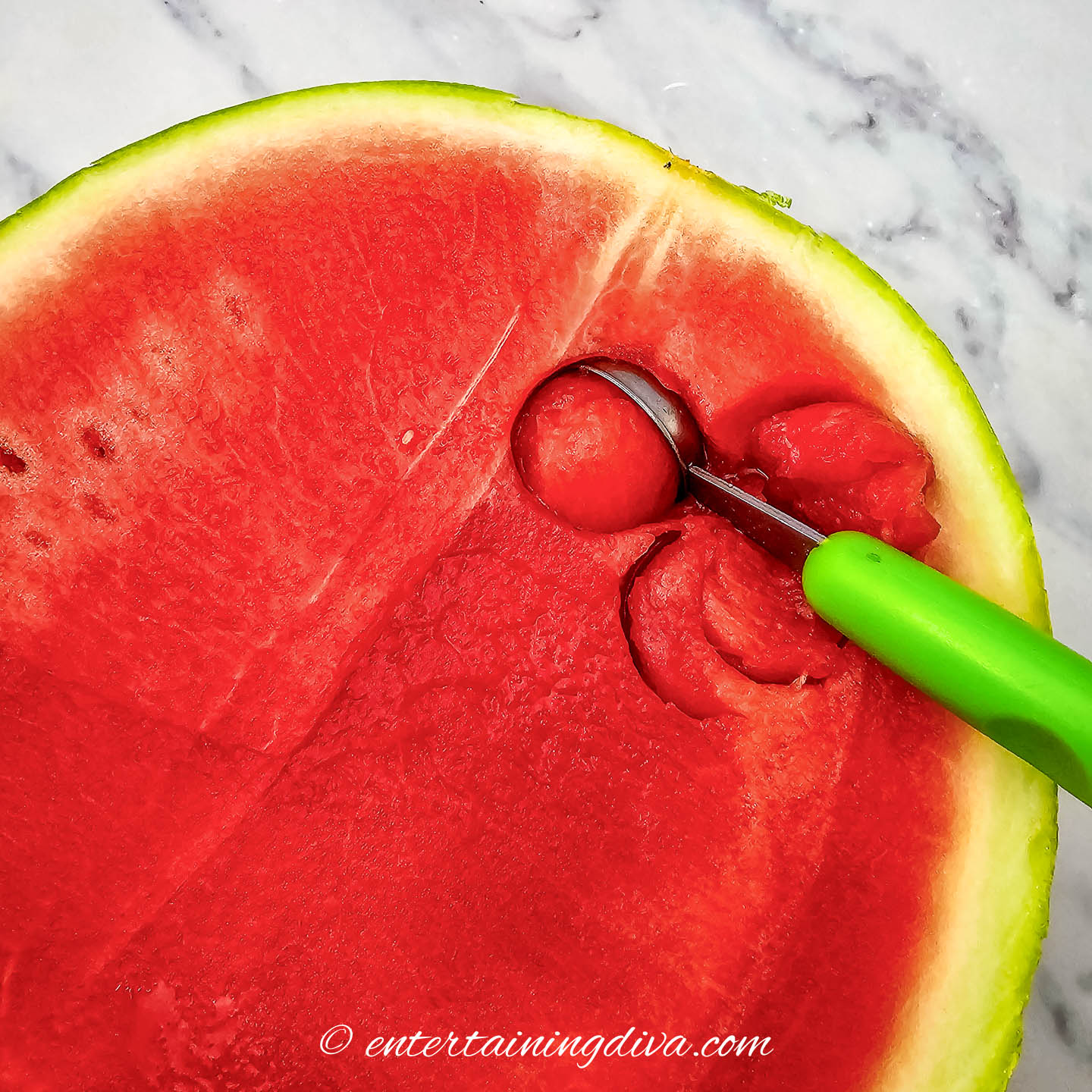balls being cut from a watermelon with a melon baller