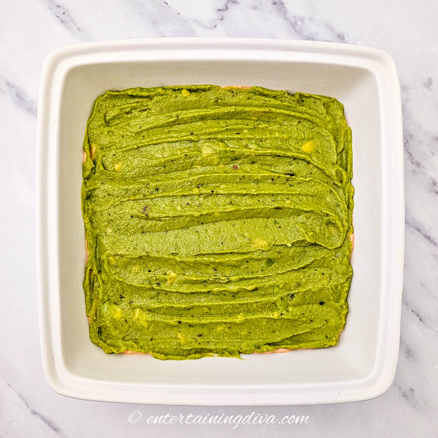 a layer of guacamole in a 7-layer dip