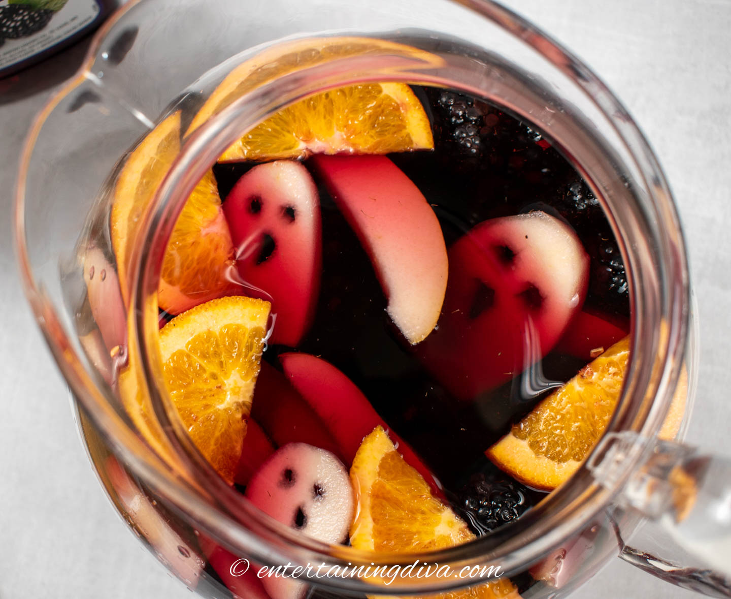 Close up of a pitcher of Halloween Sangria with pear ghosts floating in it