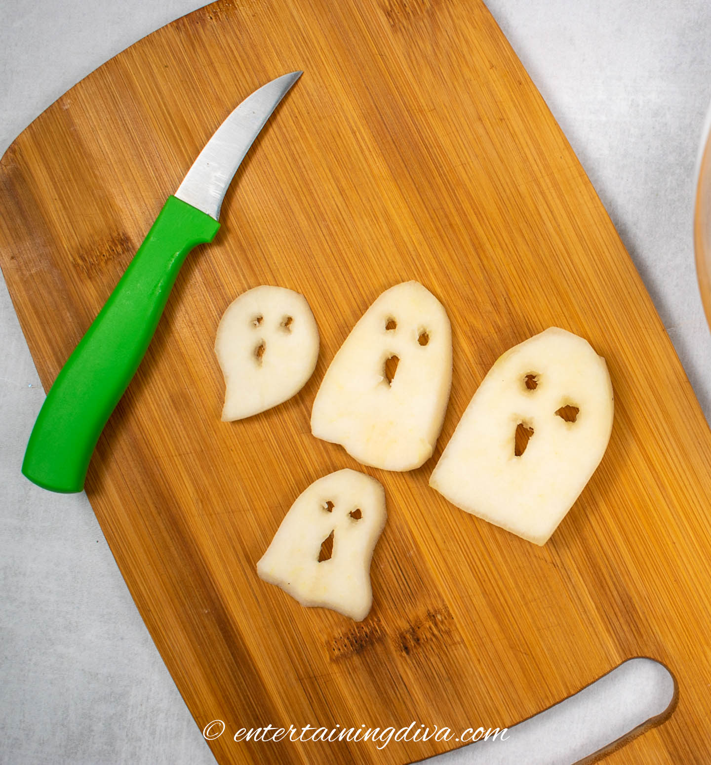 Ghosts cut from pear slices on a cutting board