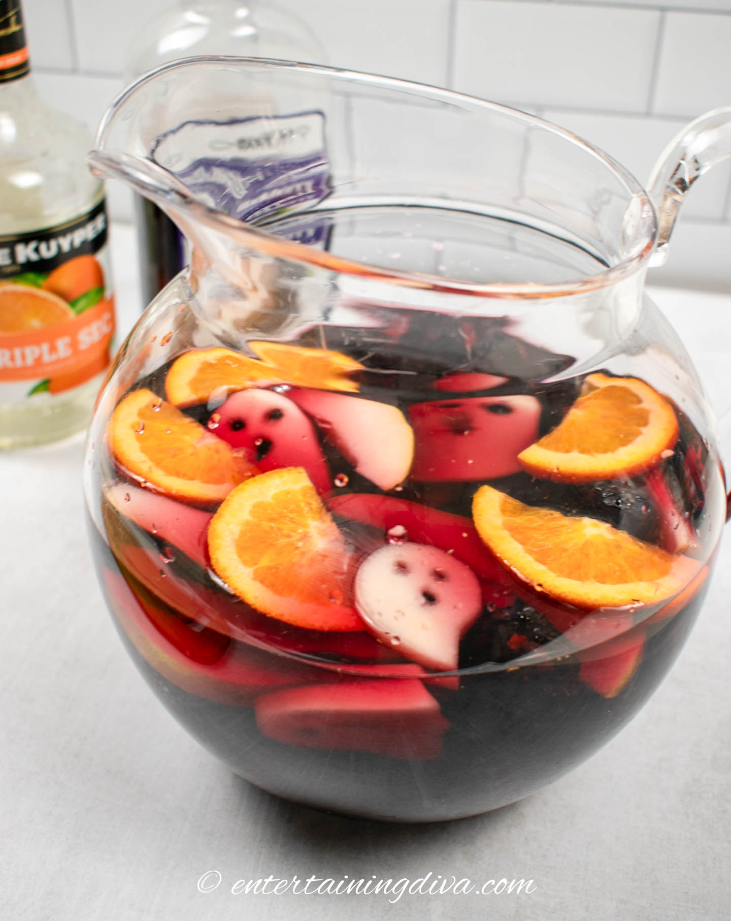 A pitcher of blackberry Halloween sangria with ghost garnish