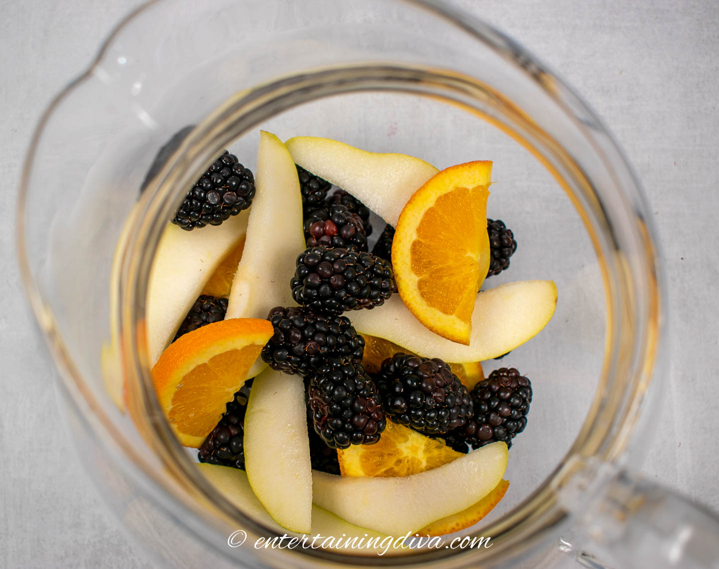 Blackberries, pears and oranges in a pitcher