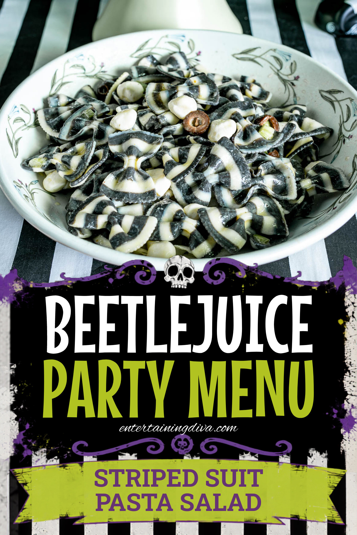 A bowl of black and white striped bowtie pasta mixed with mozzarella balls and olives, placed on a striped tablecloth.
