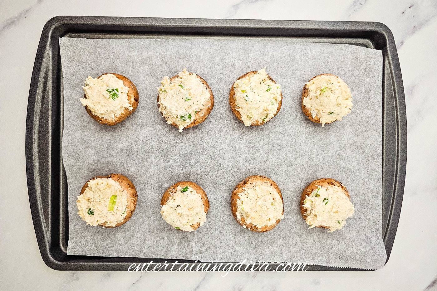 crab-stuffed mushrooms on a baking sheet before baking