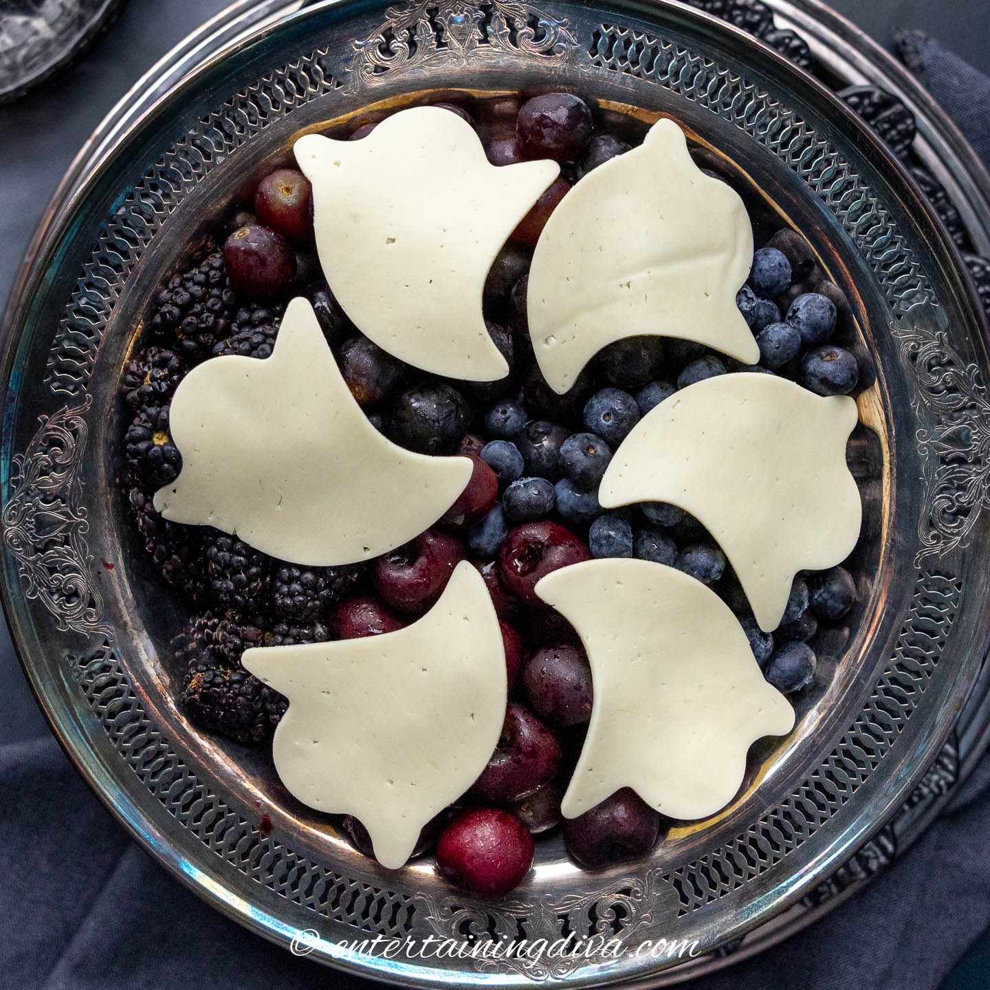 dark fruit salad with ghost-shaped cheese slices on top