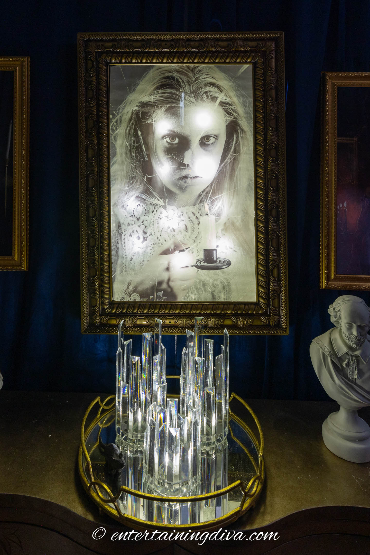 A Halloween haunted mirror on the wall above a console table