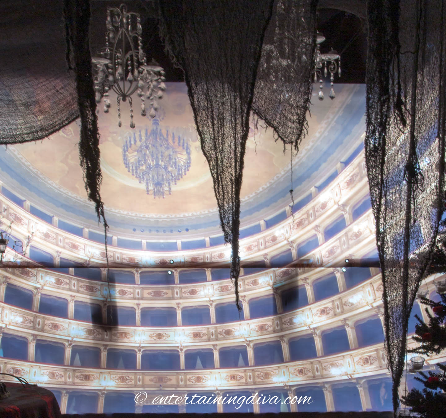 A haunted opera house backdrop lit from behind with creepy cloth hung in front