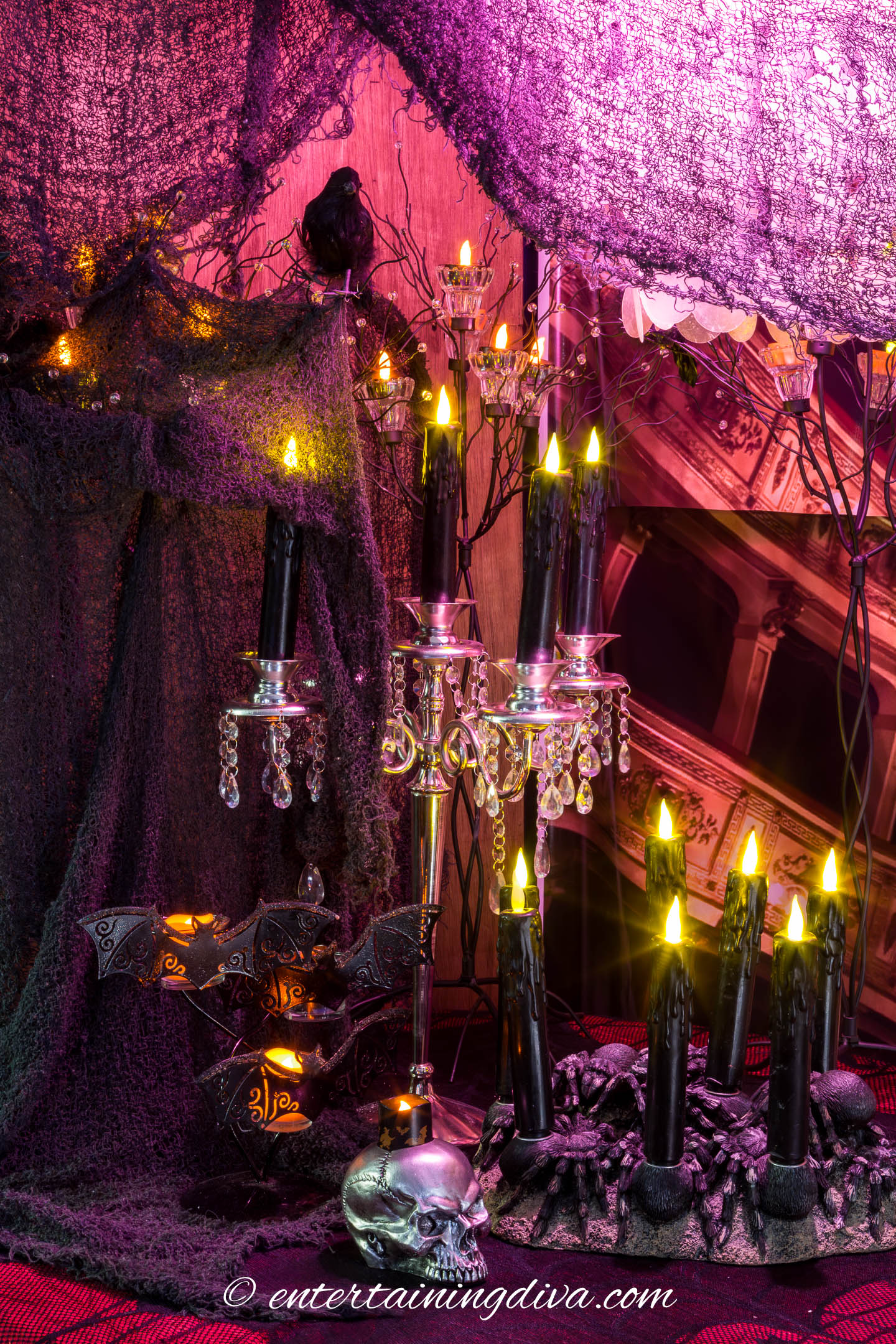 Black flameless candles in Halloween candle holders with creepy cloth and crows in the background