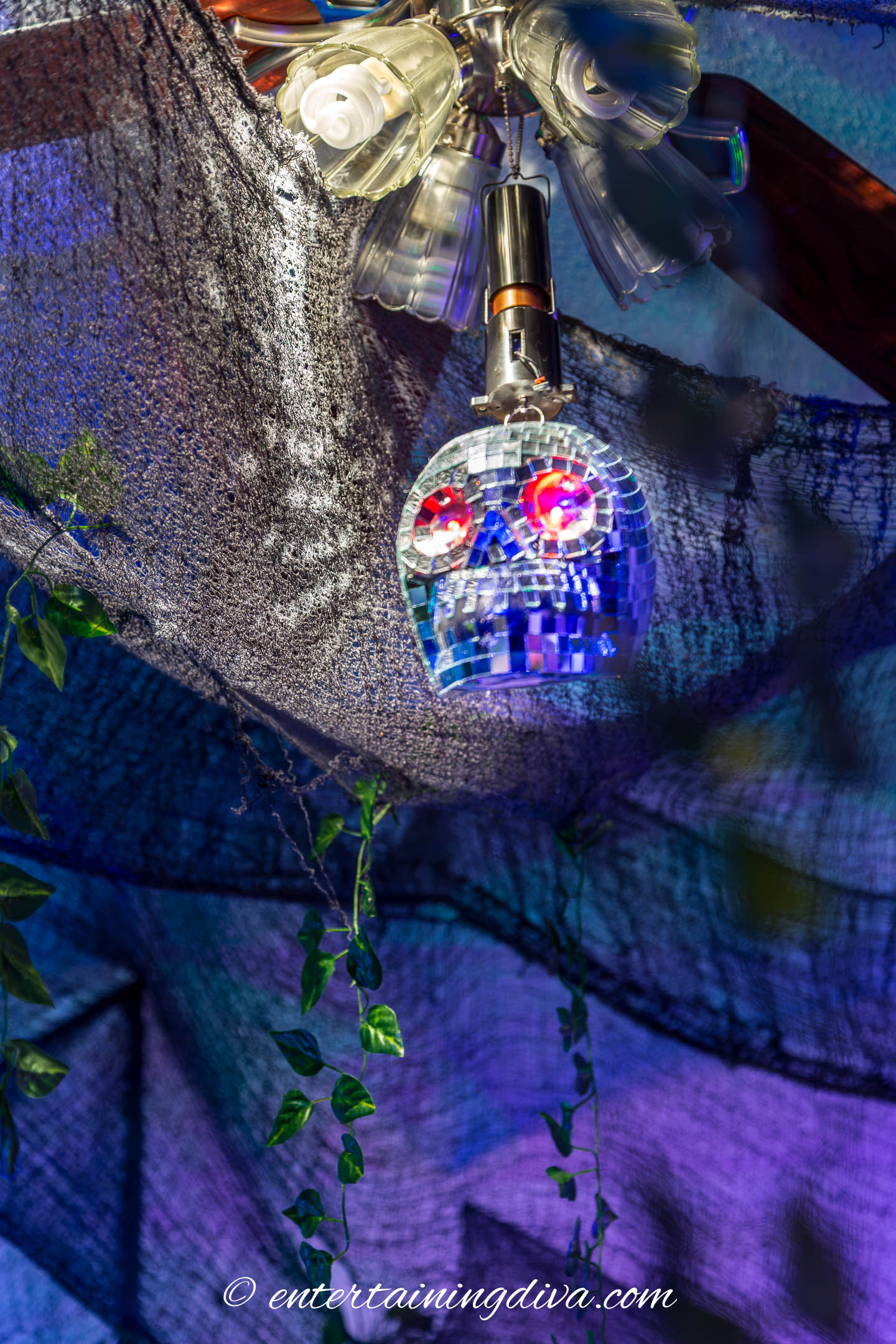 A skull mirror ball hanging from the ceiling of a Halloween haunted house.