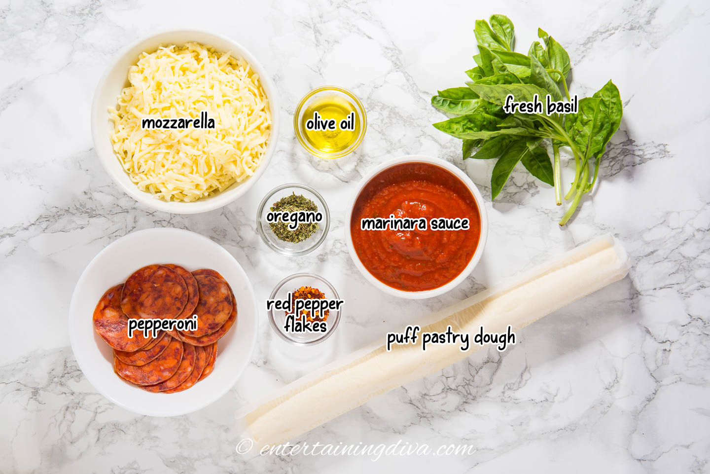 pepperoni pinwheels ingredients - mozzarella, puff pastry dough, marinara sauce, pepperoni, olive oil, oregano, red pepper flakes and fresh basil