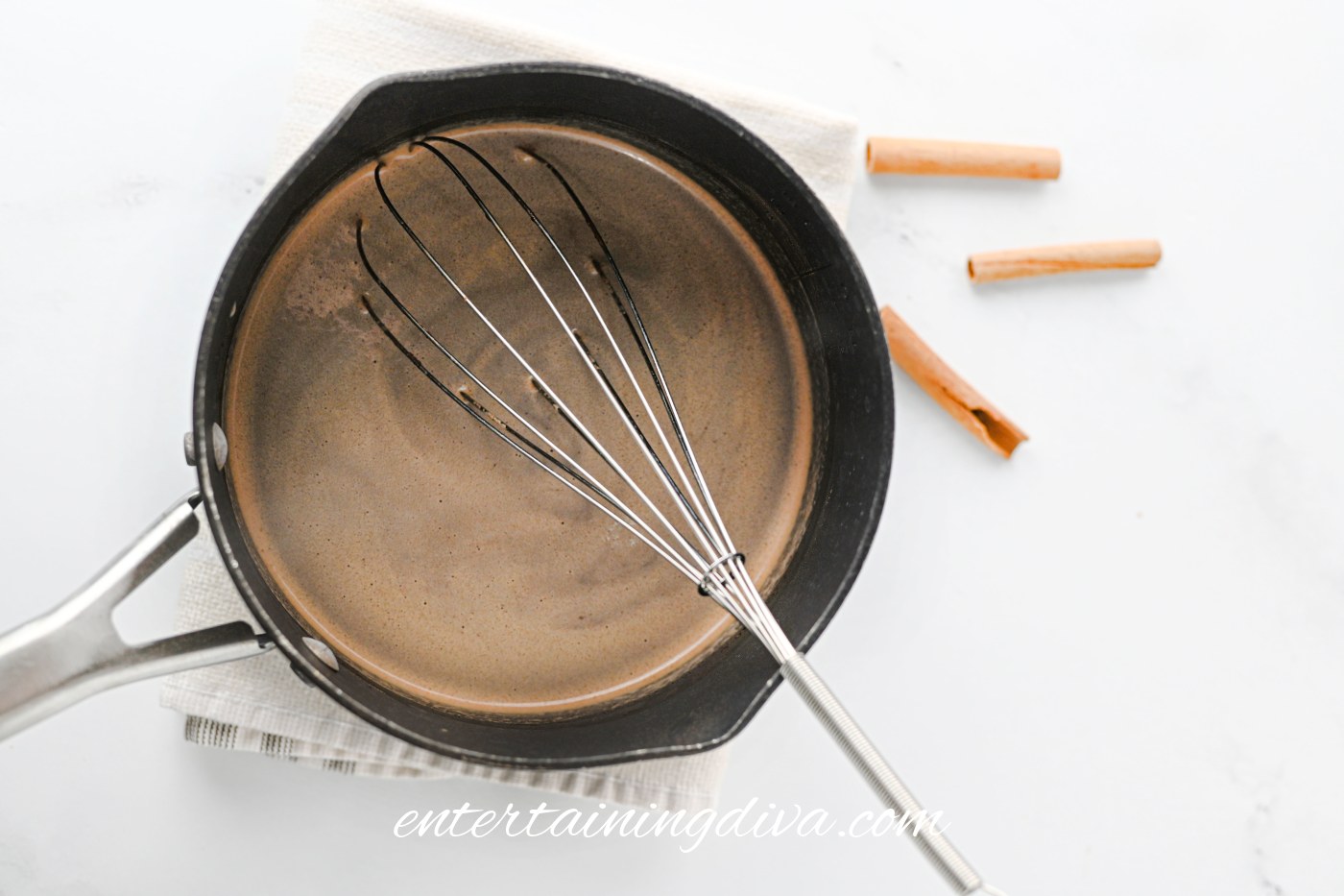 Smooth hot chocolate in a saucepan with a whisk