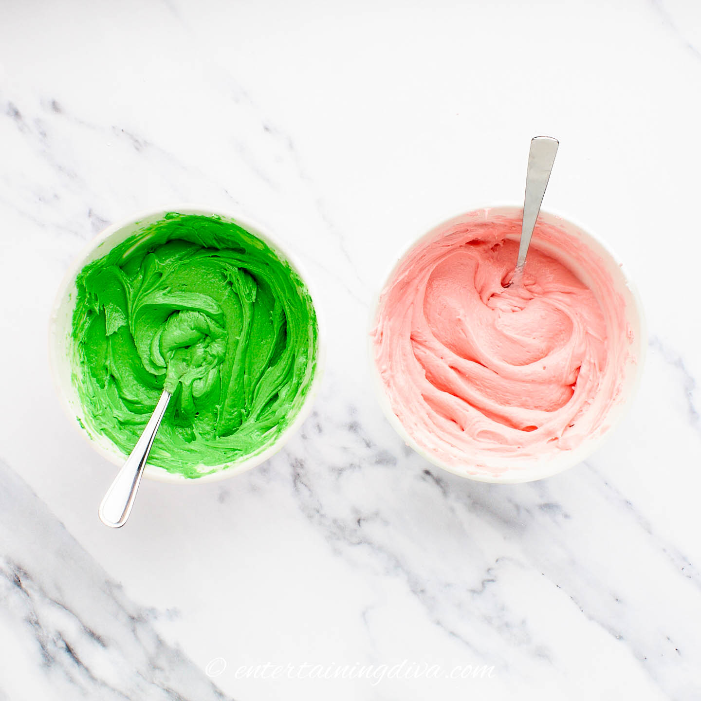 Two bowls of frosting - one colored green and the other colored pink