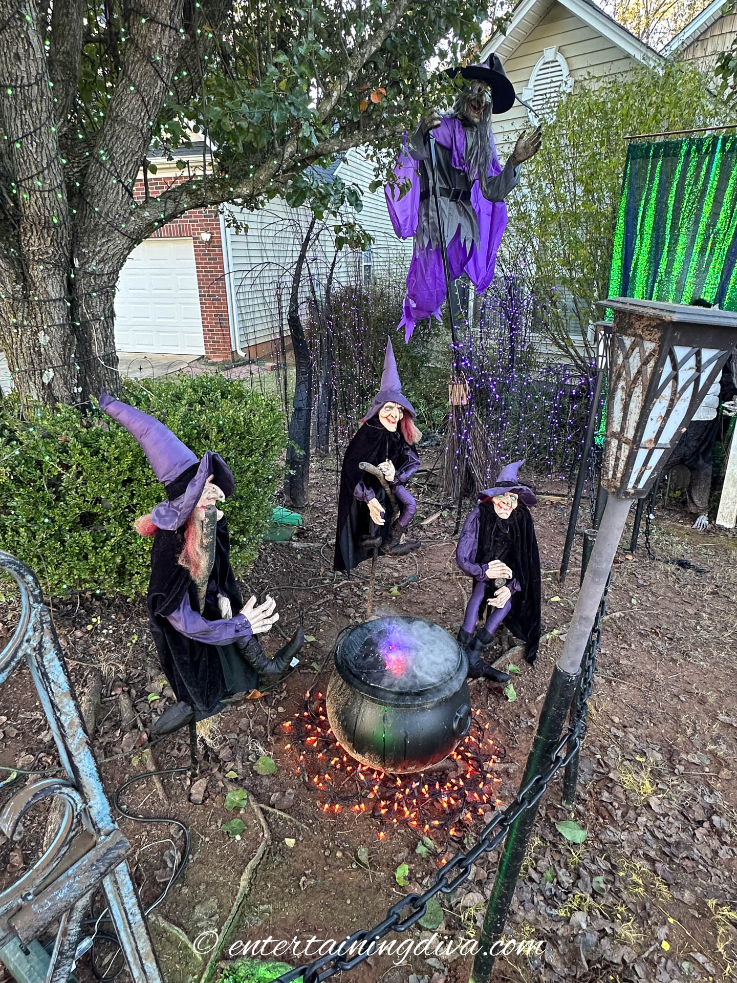 A trio of witches around a steaming cauldron in front of a tall flying witch