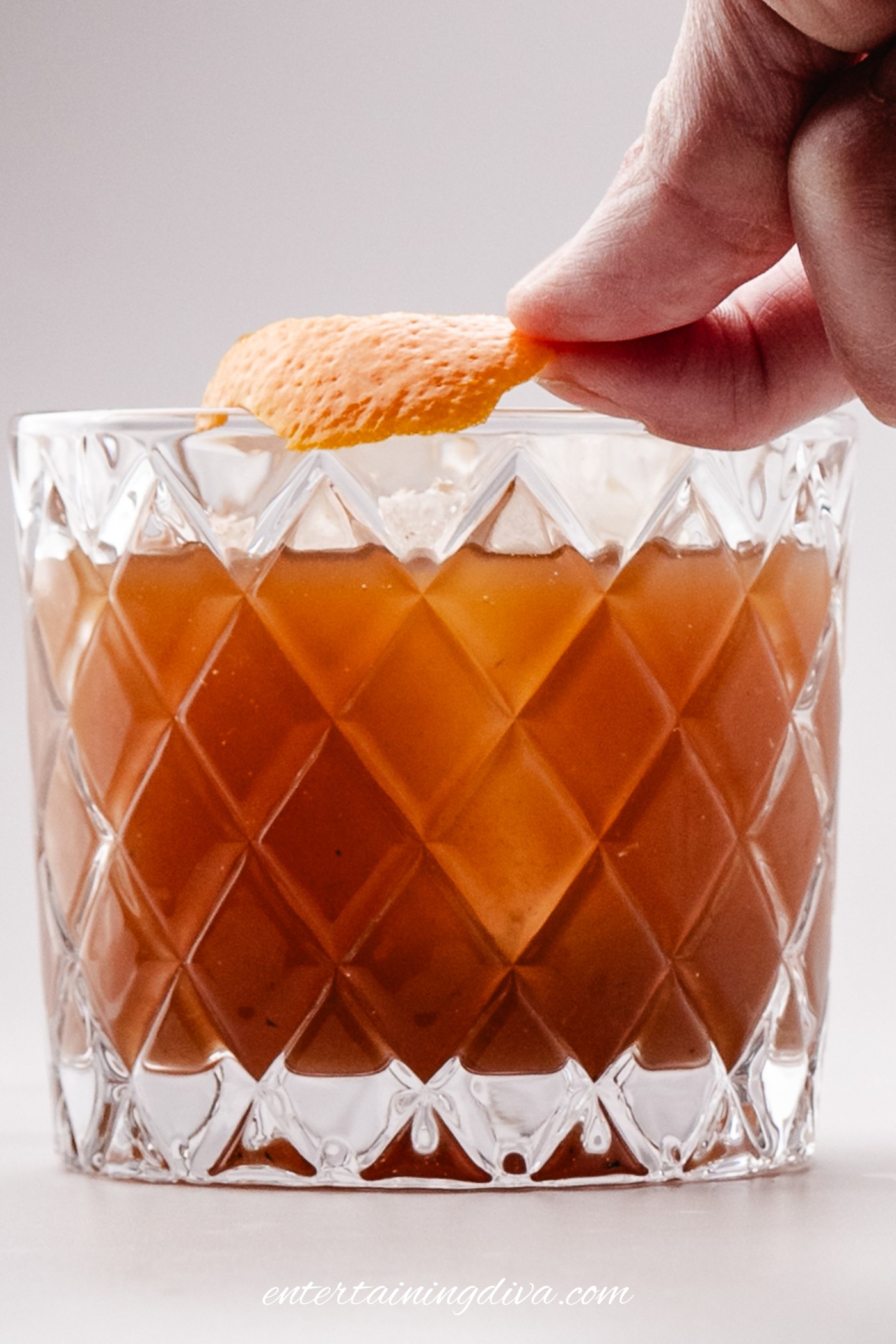 Orange peel being expressed over the cocktail
