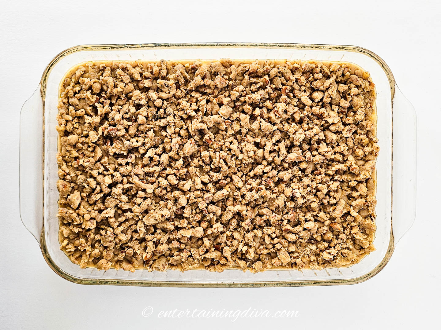 apple cake with walnut crumb topping in a baking pan before baking