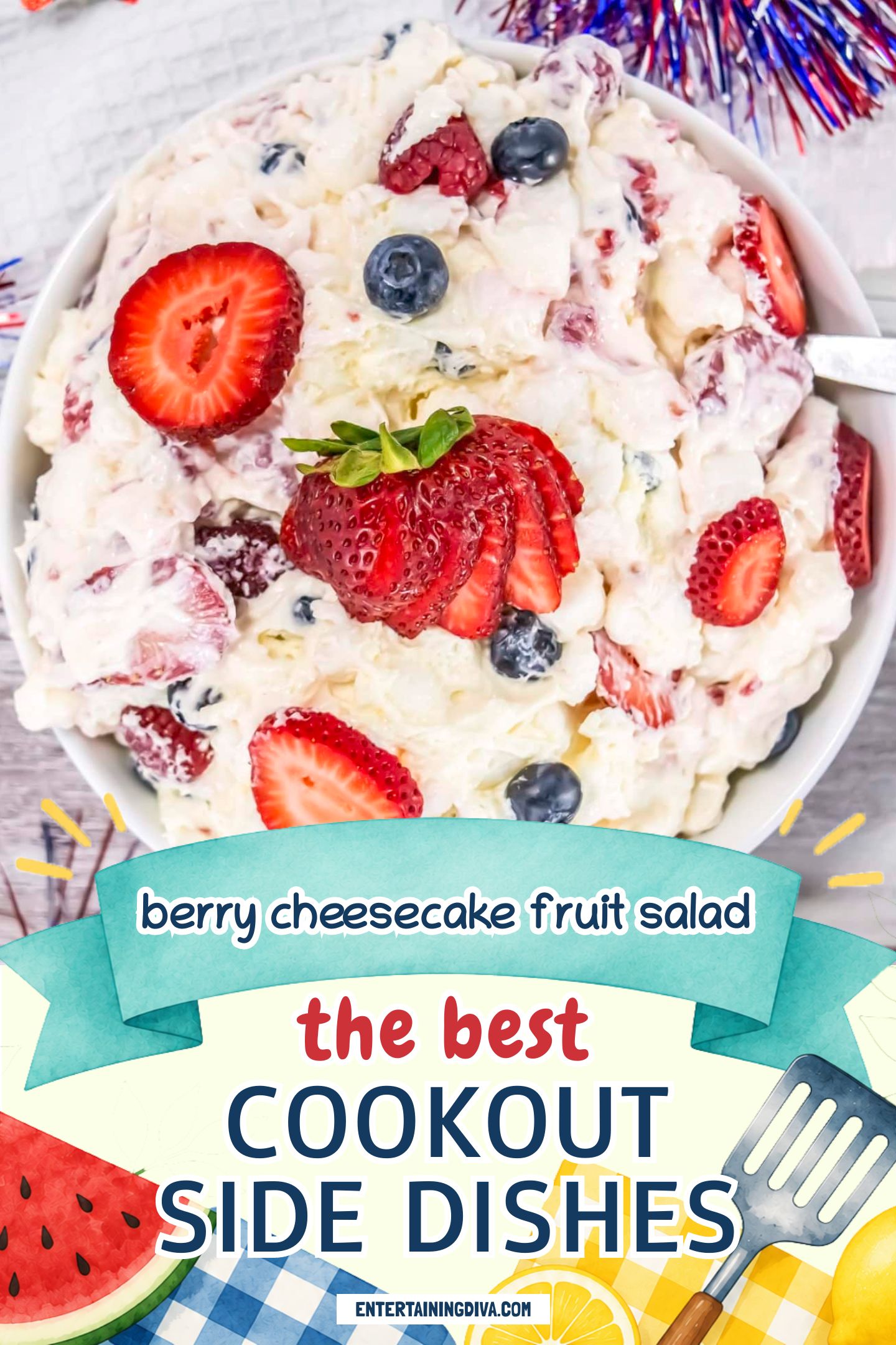 A bowl of berry cheesecake fruit salad with whipped cream, topped with sliced strawberries, blueberries, and pineapple, on a wooden surface with 4th of July decorations.