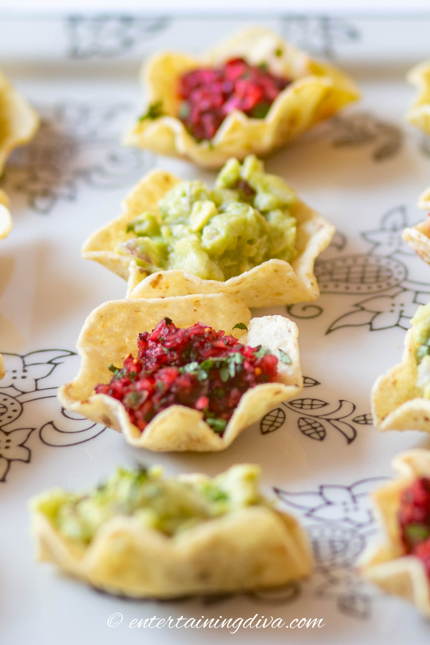 cranberry salsa bites with guacamole bites on a tray