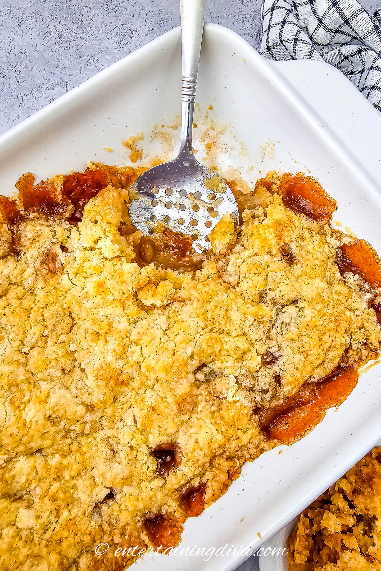 Easy apple cobbler in a baking dish with a serving spoon and a scoop taken out of it