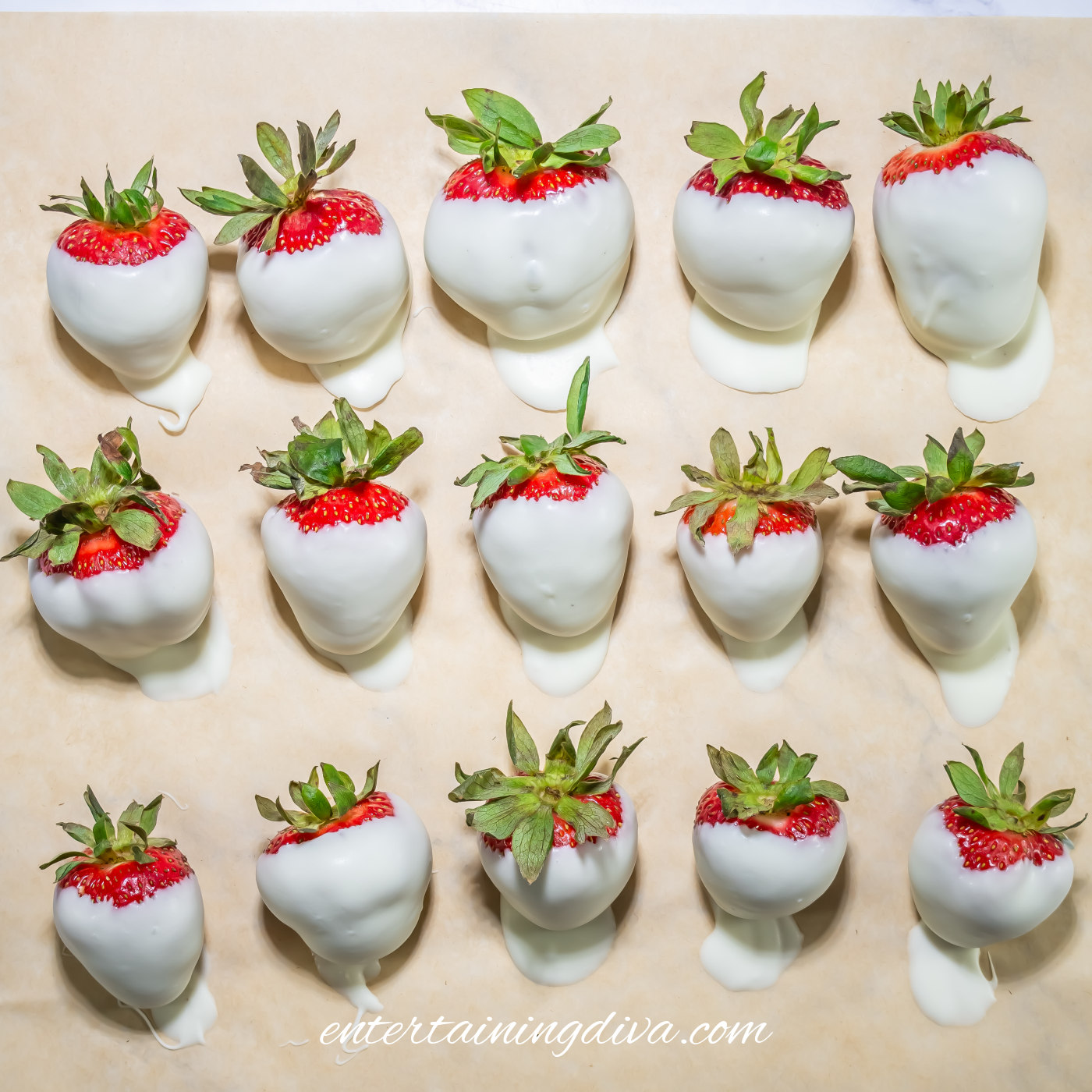 Strawberries dipped in white chocolate on parchment paper