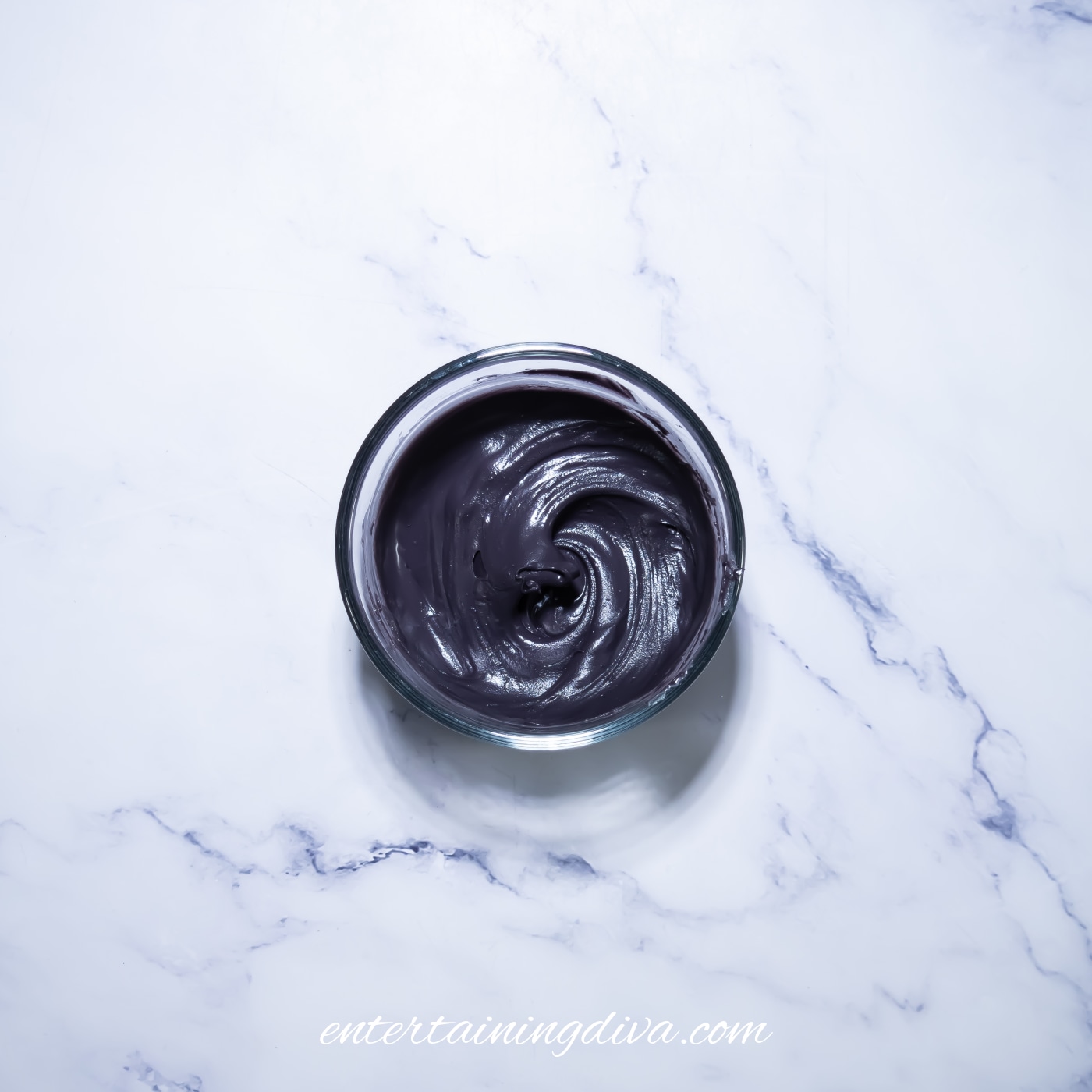 Melted black candy coating in a small bowl