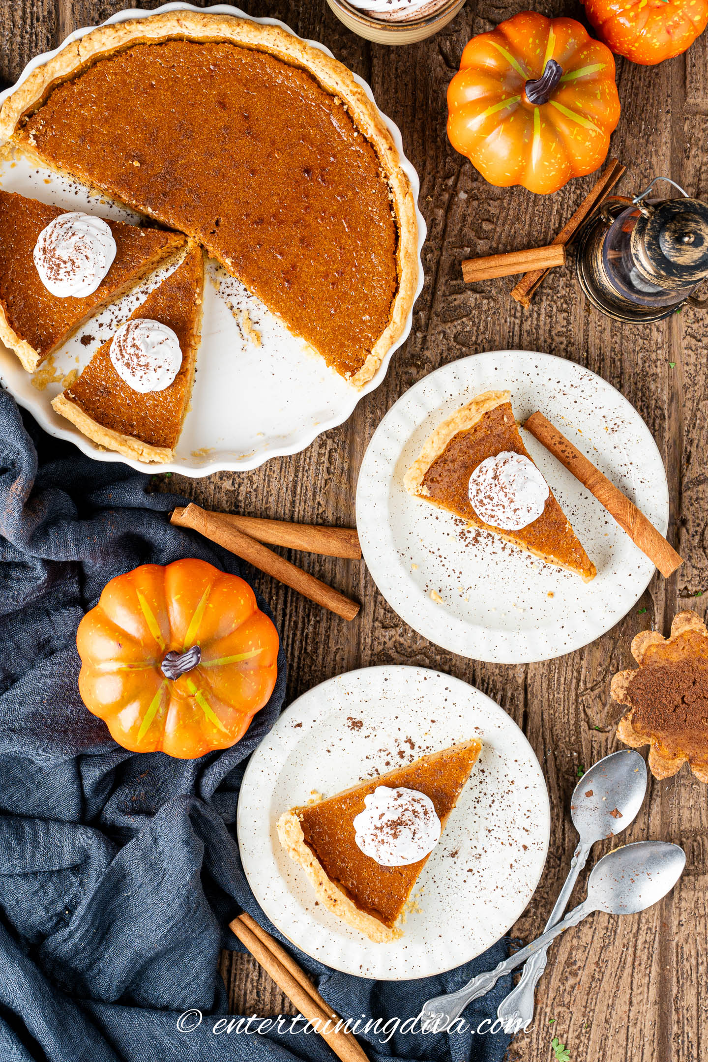 overhead picture of two slices of pumpkin pie on plates beside the rest of the pumpkin pie in the pan