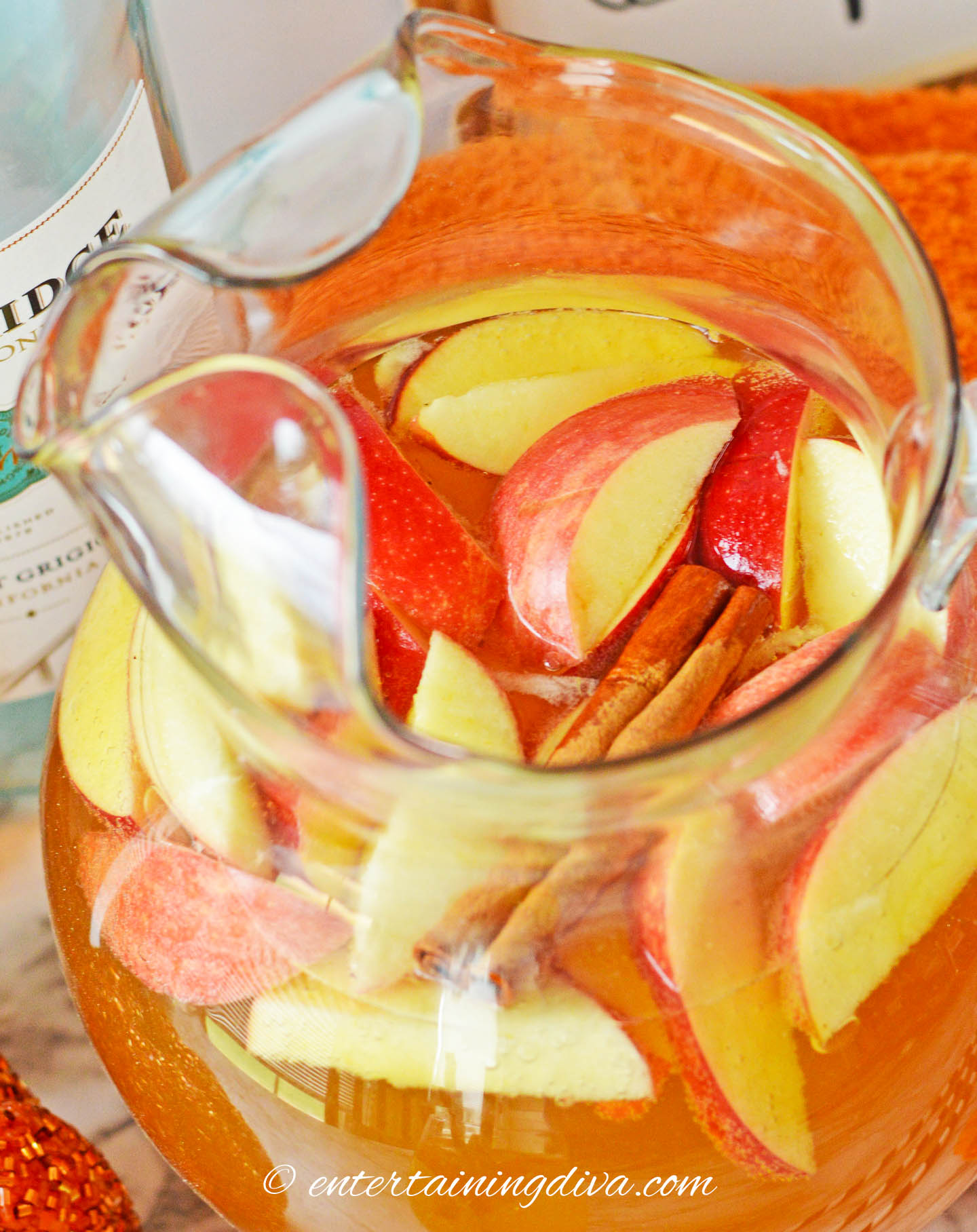apple slices floating at the top of a pitcher of pumpkin sangria