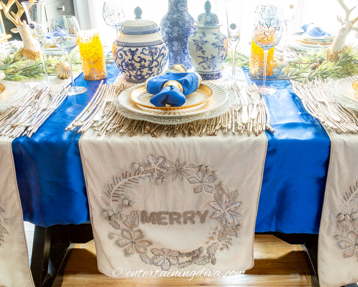White velvet runners on a blue tablescape for a blue, white and gold Christmas tablescape
