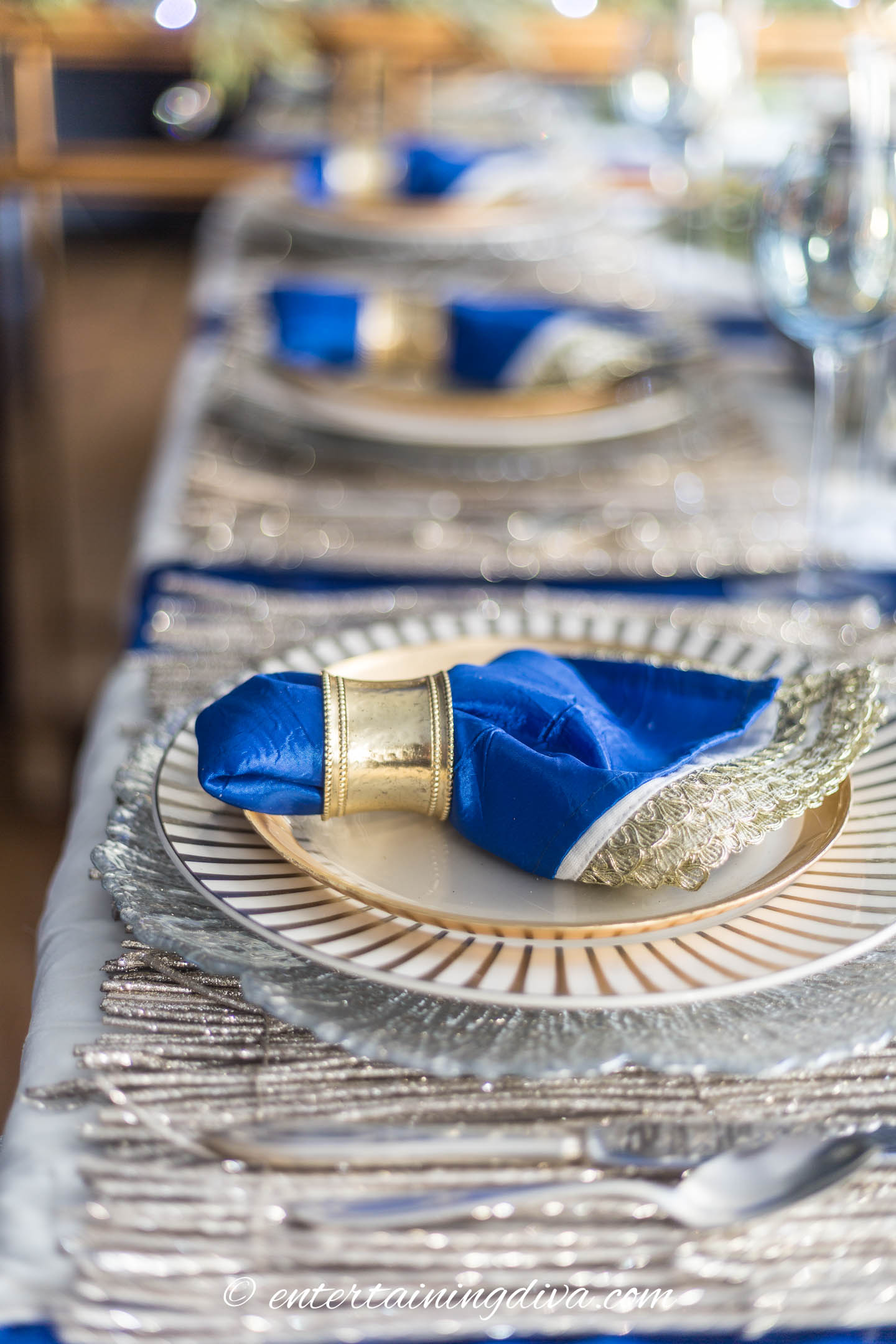 Close up of a blue, white and gold place setting on a gold twig place mat