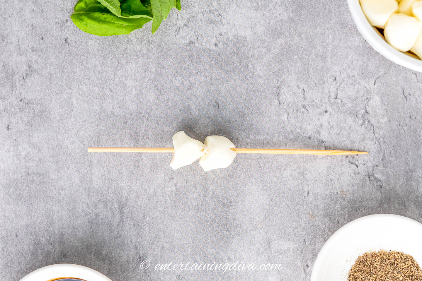 2 small mozzarella pearls on a skewer