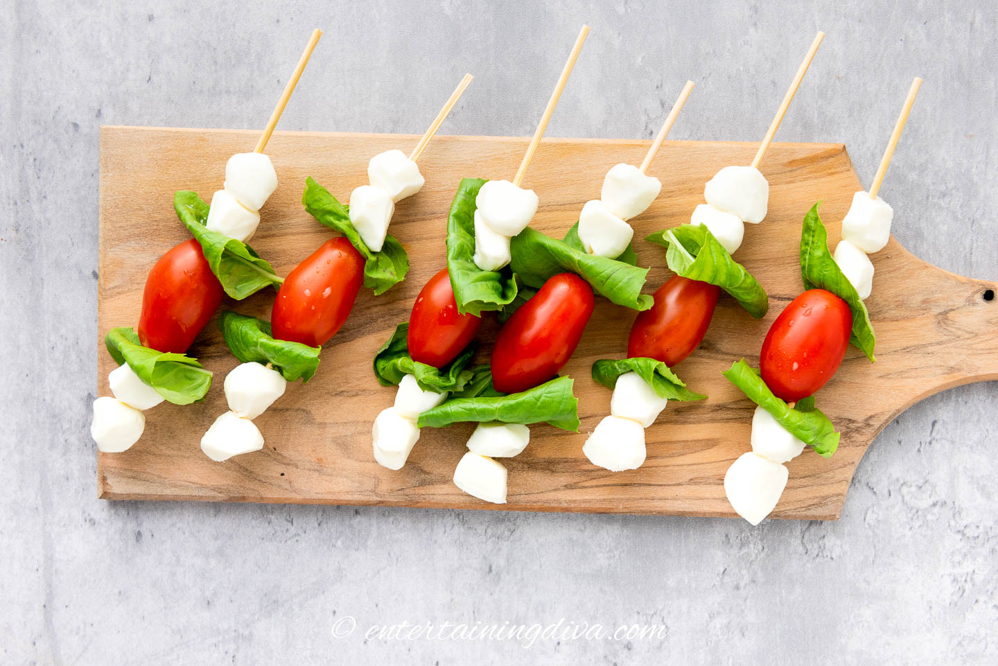 caprese skewers laid out on a serving board