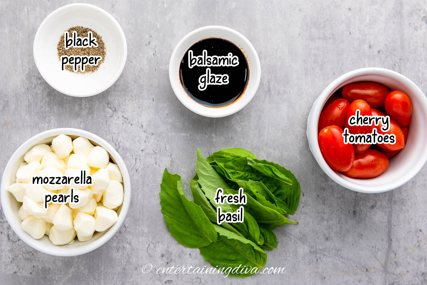 caprese skewers ingredients - tomatoes, basil, mozzarella, balsamic glaze and black pepper