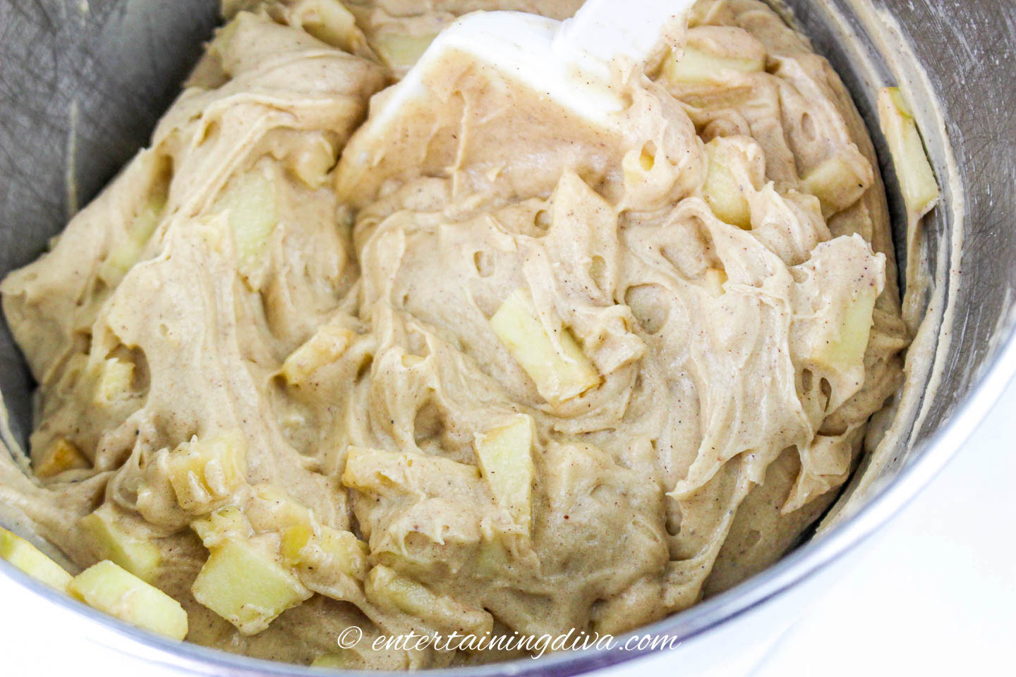 diced apples being folded into the caramel apple sheet cake batter