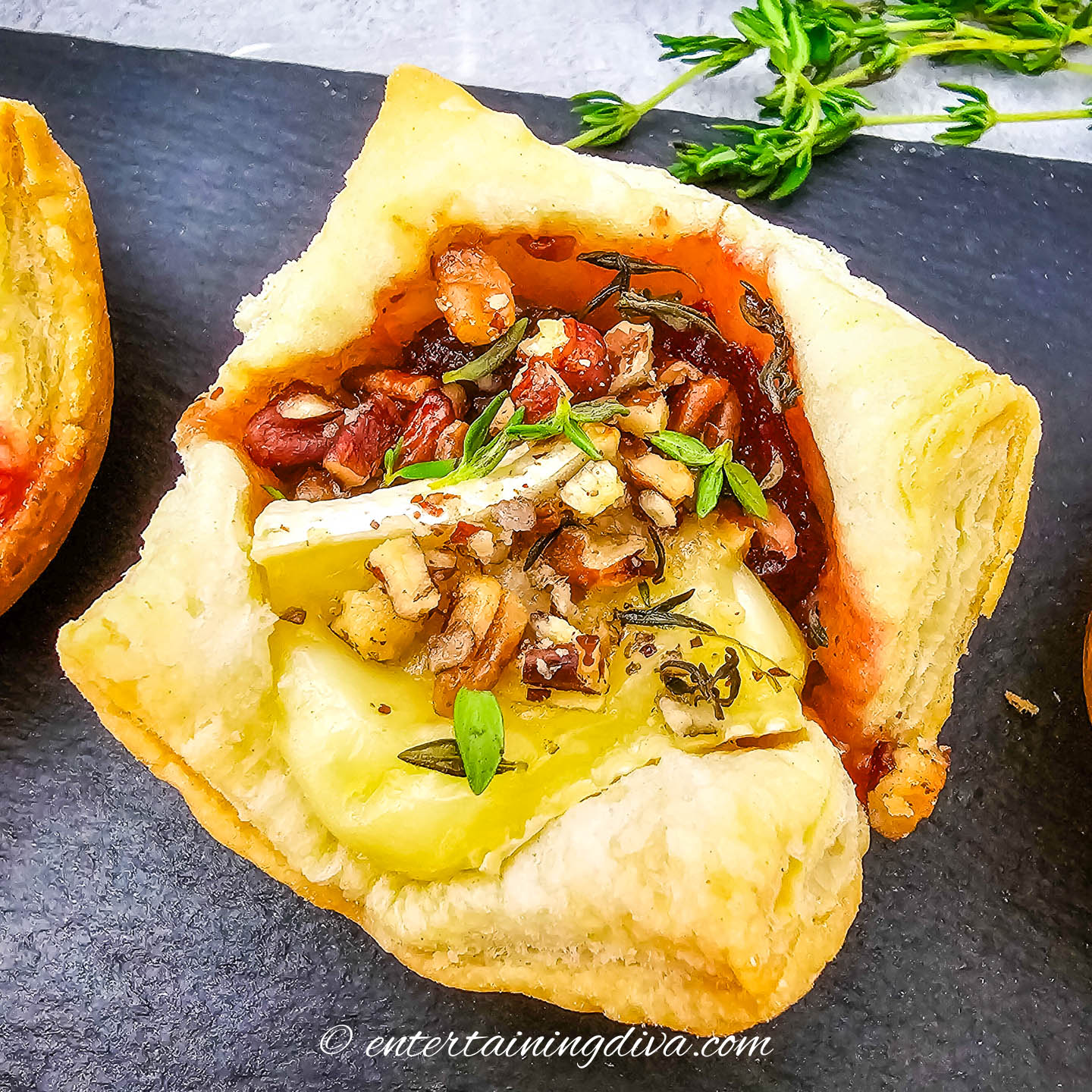 overhead view of fresh thyme sprinkled on baked cranberry brie bites