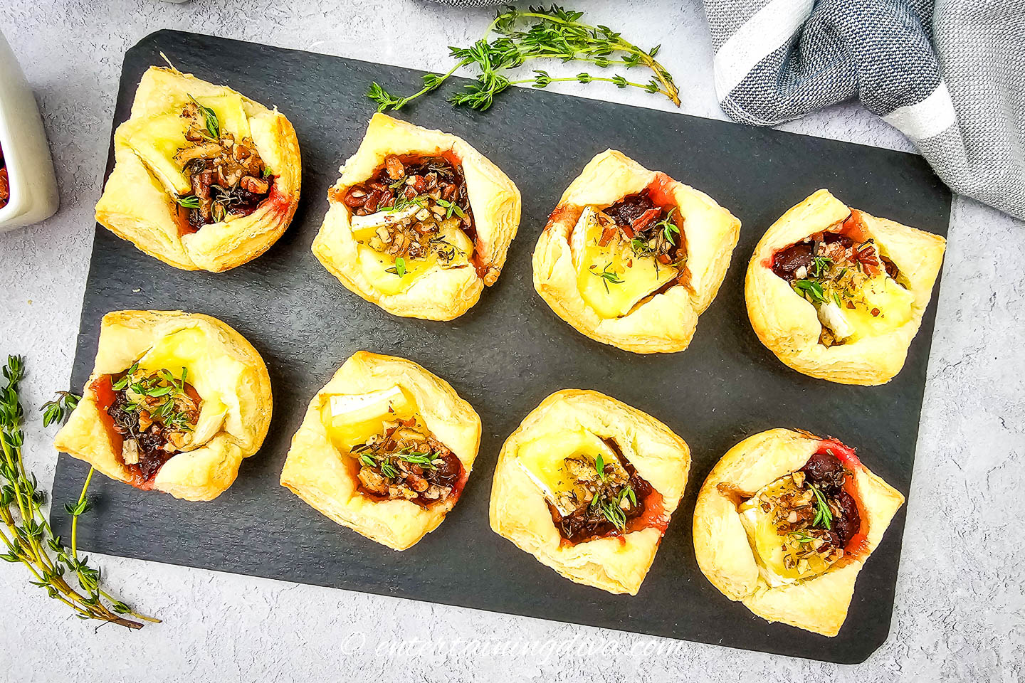 8 cranberry brie bites on a black serving tray
