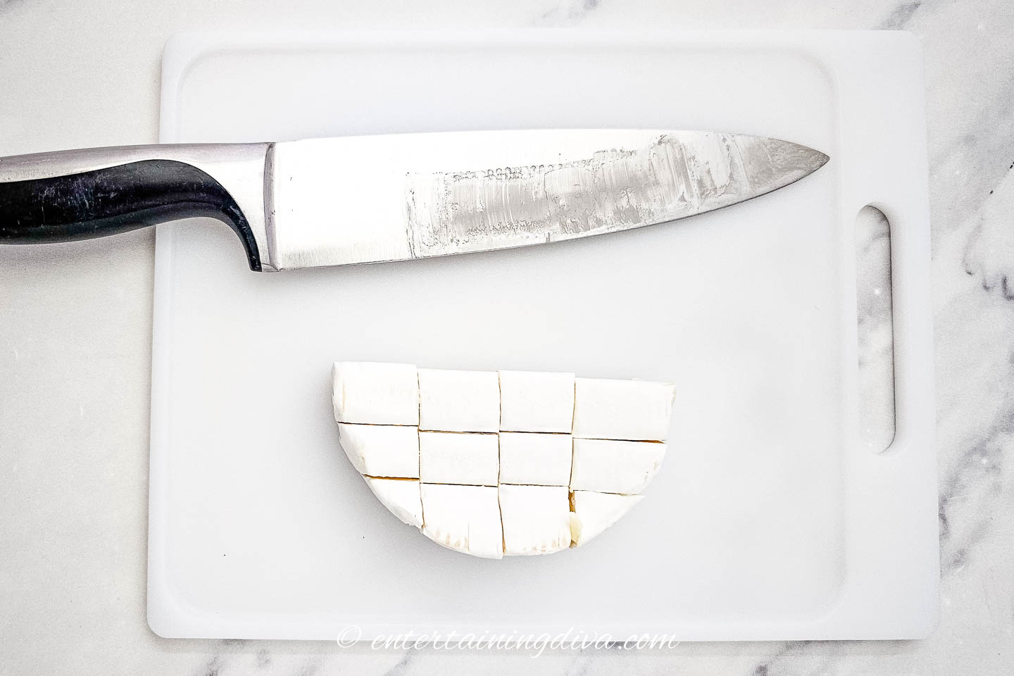 chopped brie on a cutting board with a knife