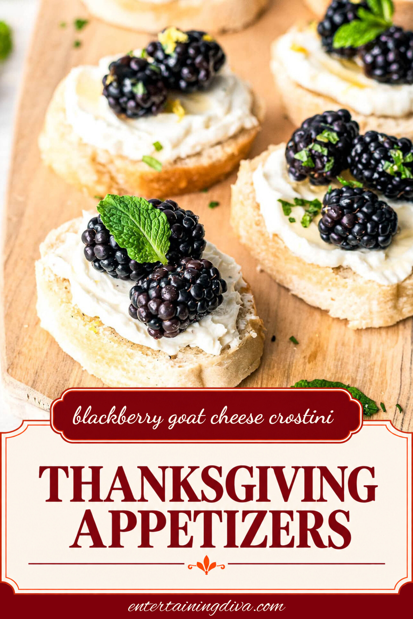 close up of 3 blackberry goat cheese crostini appetizers garnished with mint leaves on a cutting board