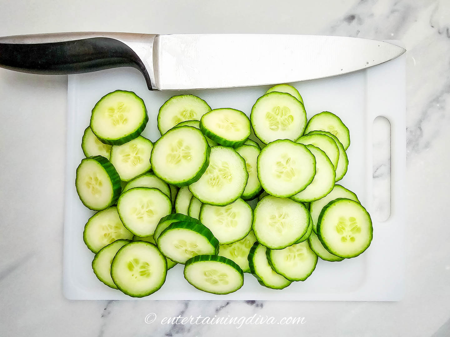 cucumber slices on a cutting board with a knife